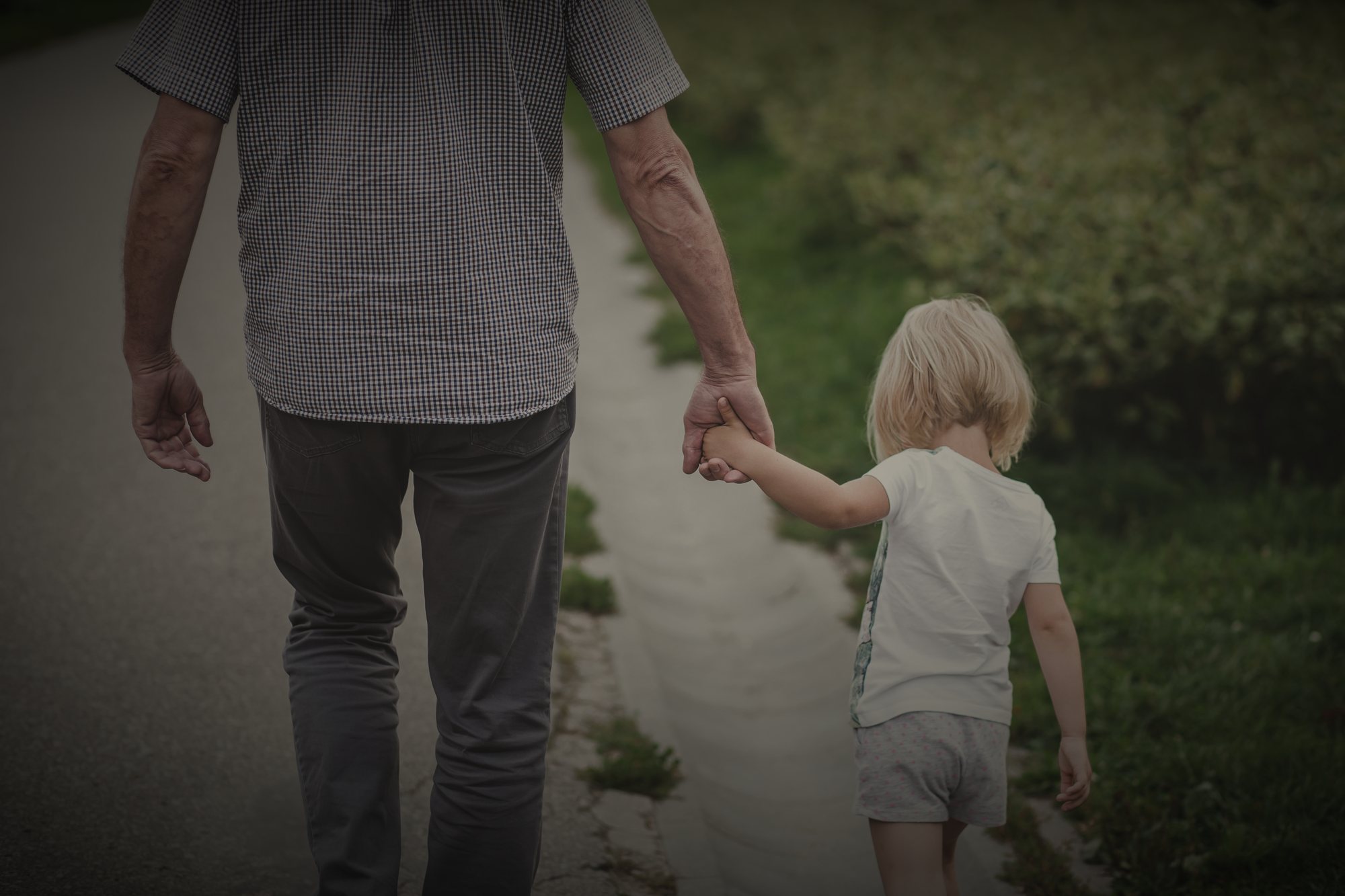 A grandfather and child walking hand in hand